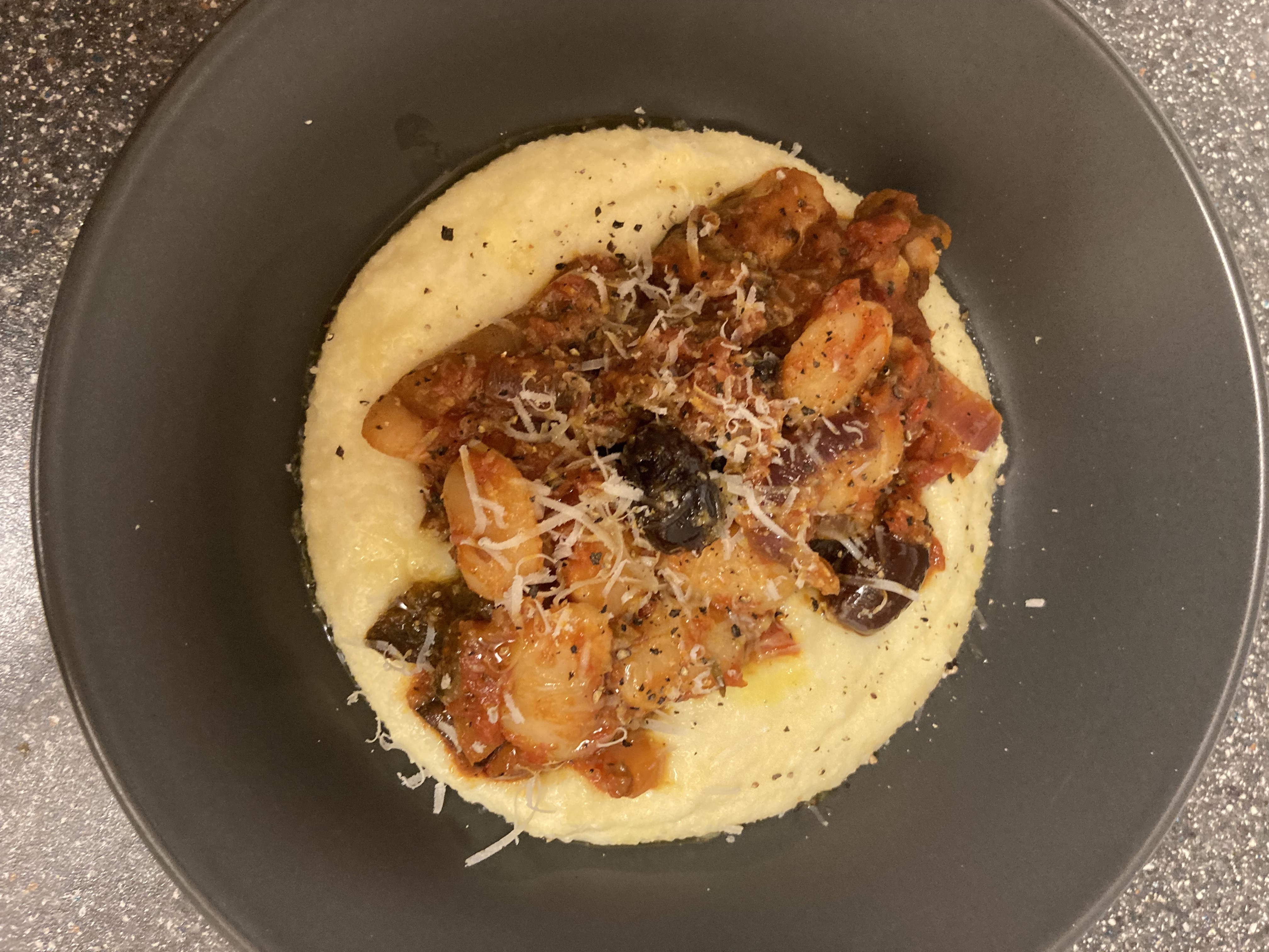 tomato bean caponata over creamy polenta in a wide grey bowl