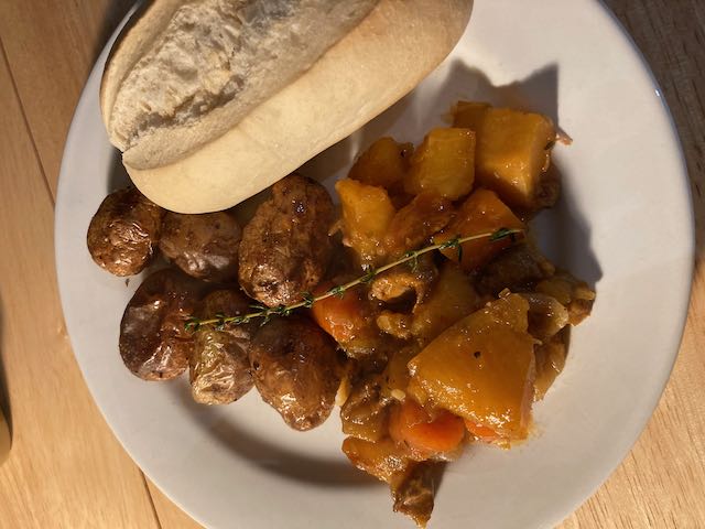 Irish lamb stew with roasted potatoes and a bread roll